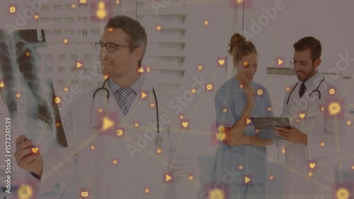 Doctor examining X-ray causing icons drifting while nurse and peer tapping tablet for diagnosis