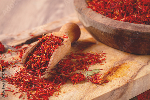 Fototapeta Naklejka Na Ścianę i Meble -  Spice saffron threads, in a wooden bowl, on a wooden table, top view, close-up,