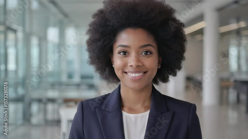 Confident African American Businesswoman with Natural Curly Hair Smiling in a Modern Office Environment