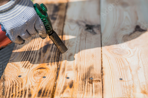 The process of burning wooden boards with a burner. The texture of wood treated with fire from a burner. Close-up.