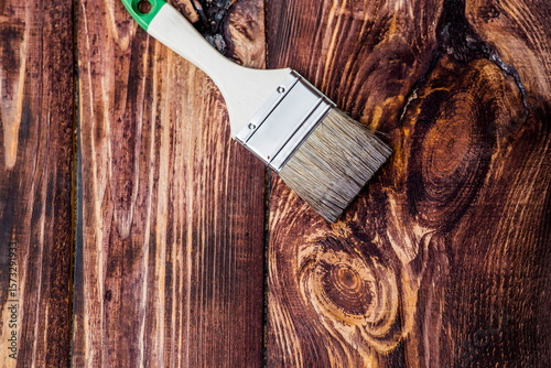 The procedure for protecting and coating wooden boards. The texture of wood treated with stain. Close-up of stain and brush.