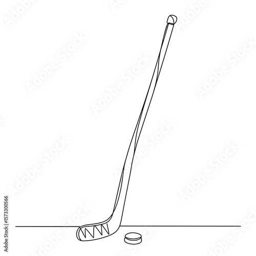 Hockey stick leaning against wall with puck on the floor  