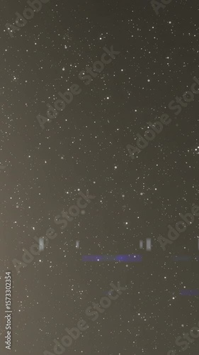 Animation of snow falling over silhouette of moon in winter scenery