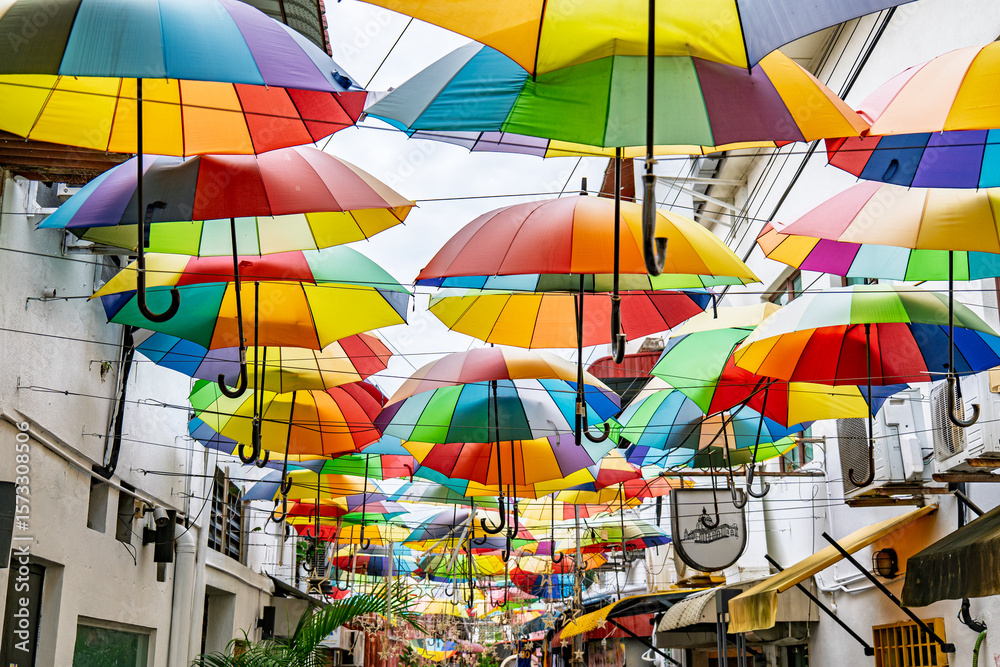 Fototapeta premium Colourful rainbow of umbrellas shade a laneway off Armenian St in George Town's heritage area.