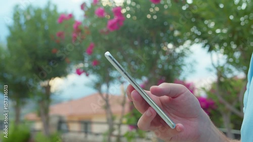 Hands of a man using a mobile phone. A man browsing an app on his mobile phone, close-up.