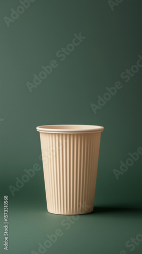 Simple beige cup on a green background showcasing minimalist design and texture ideal for creative settings