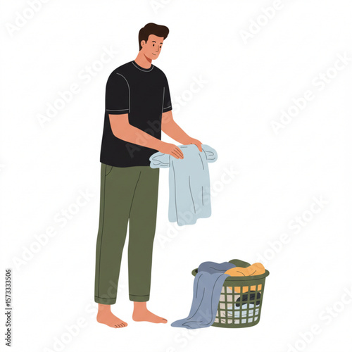 A man carefully folds clean laundry, placing it neatly aside from a laundry basket overflowing with clothes.