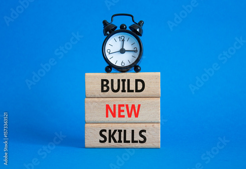 Build New skills symbol. Concept word Build New skills on wooden blocks with alarm clock. Beautiful blue background. Business and Build New skills concept. Copy space