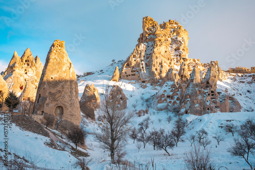 Snow-covered rock formation and a tree in Cappadocia. Breathtaking view of Valley in winter season, Uchisar Ortahisar Cappadocia National park. Ortahisar Town at snowy day in Uchisar. A magical winter