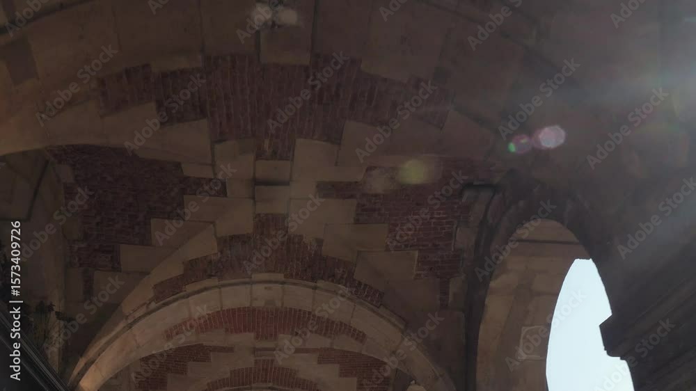 Détail d’une voûte en pierre et briques à Paris avec rayons de soleil et effet de lens flare
