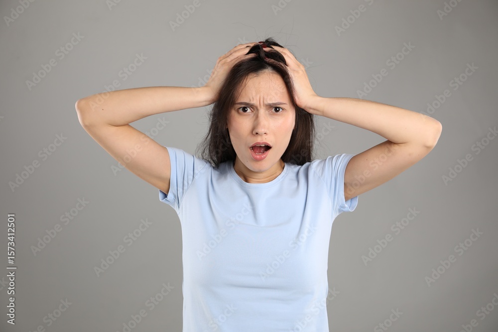 Portrait of shocked woman on grey background Portrait of shocked woman on grey background