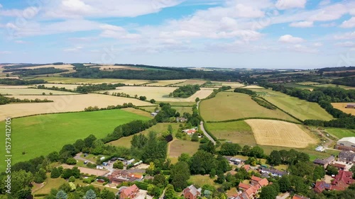 Aerial drone footage of the beautiful village of Burnby in the East Riding of Yorkshire, near York in the UK showing the quant little village alongside farmers fields and hill's in the summer time