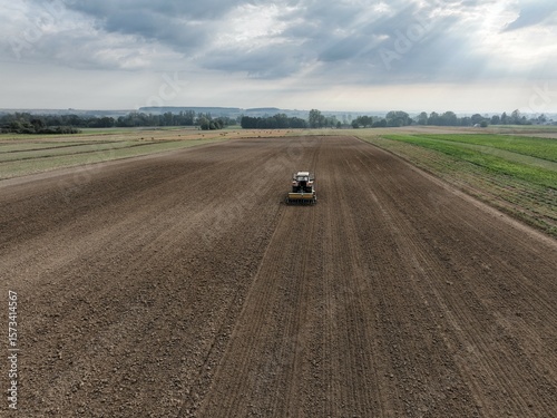 Siew rzepaku ciągnikiem z agregatem siewnym, uprawa pola i siew nasion, siew zboża siewnikiem i broną aktywną.