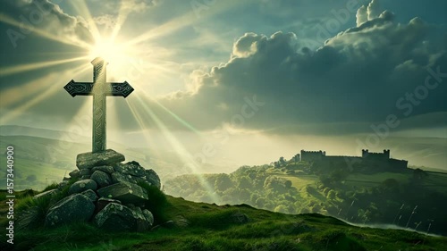 Old cross on a green hill with English castle and sunshine in the sky. Heavenly light behind ancient symbol of faith
