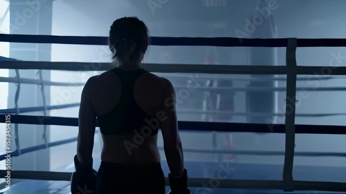 Back view of a person preparing for training in a boxing gym during early morning hours