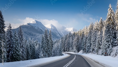 winter scene depicts a snowy road winding through frosted evergreen forest toward distant peaks