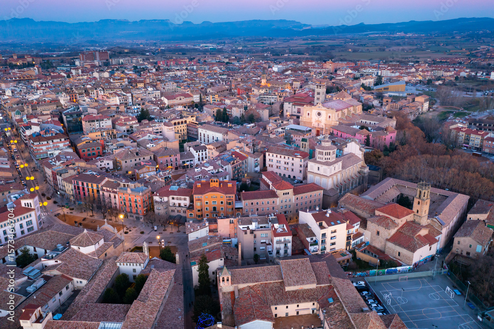 Obraz premium View from drone of Spanish town of Vic with tiled roofs of old buildings and ancient cathedral in winter evening, Barcelona province, Catalonia