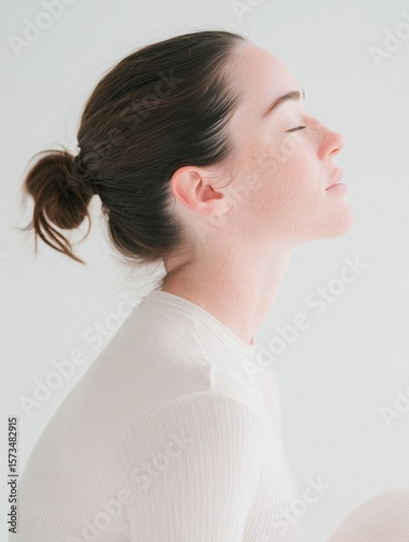 Side profile of serene woman with closed eyes in soft light