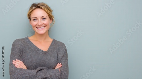 Smiling Woman in Casual Sweater Against a Soft Green Background