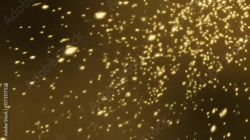 Shimmering gold dust particles floating in dark background  