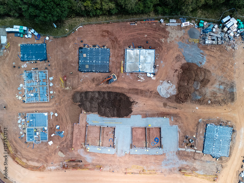 Fotografie Construction site with building foundations and an excavator working on the grou