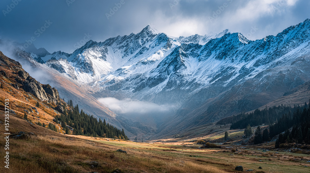 Obraz premium Majestic snowy mountains rise above alpine valley. Coniferous trees dot scenic landscape. Ideal for travel, adventure, nature marketing, web design.