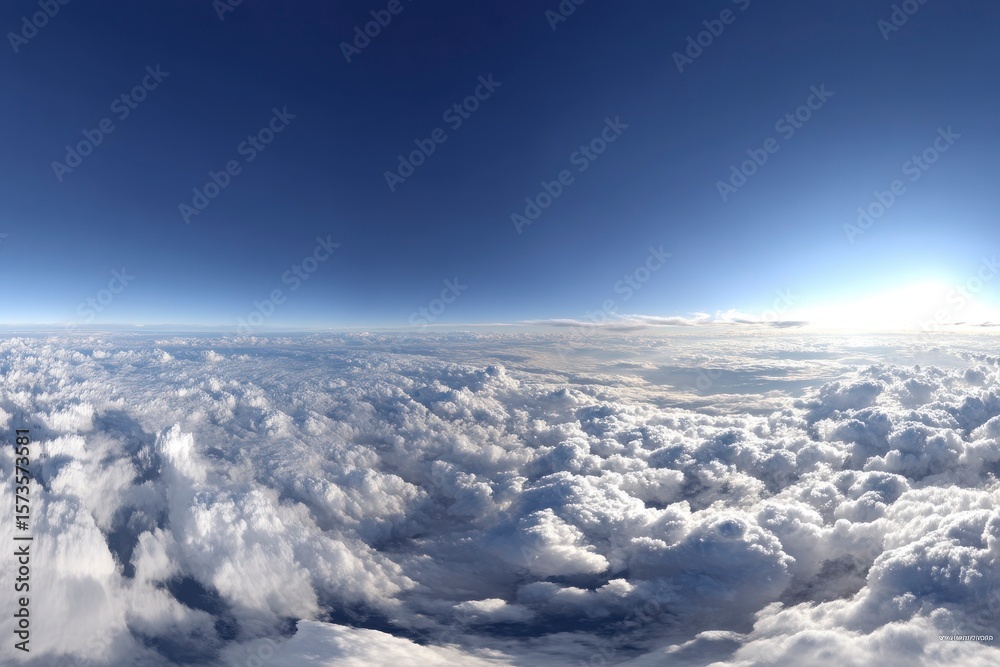 Naklejka premium Vast blue sky meets a sea of white clouds, sun bright on the horizon, panoramic view from above in the atmosphere. View from above.