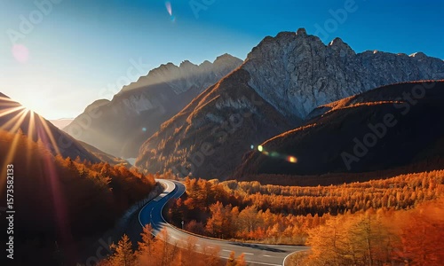 Picturesque mountain road winding through autumn foliage at sunrise with stunning scenery