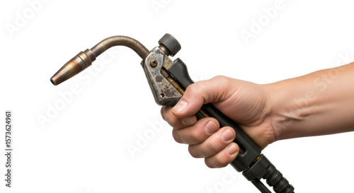 A hand holding a welding torch against a black background in a close up studio shot for industrial work