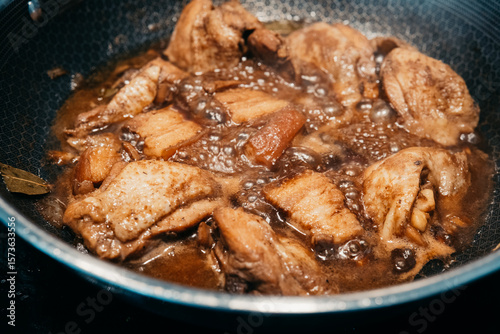 фотографія Savory chicken pork adobo simmering in a pan with rich sauce and spices