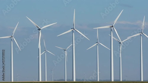 Wind Turbines Spinning with Blue Sky and Green Field Landscape for Renewable Energy Generation and Sustainable Power