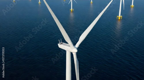 Wind Turbines Stand Over Calm Blue Sea Under Clear Skies Offering Renewable Energy