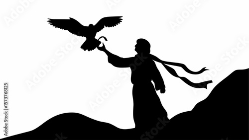 Silhouette of a man with a flowing scarf standing on a hill releasing a falcon into the sky in black and white