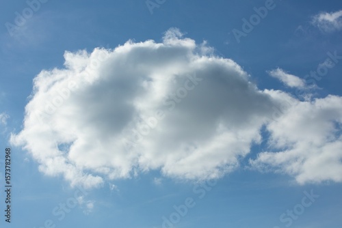 Flat design scene is showing large cumulus cloud floating in bright blue sky with wispy fragments