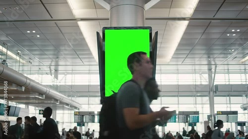 Blank Green Screen Billboard in Bustling Airport Terminal — Airport Advertising and Digital Mockup Display Concept, green screen airport, airport ads mockup, green screen billboard, airport ads
