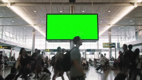 Blank Green Screen Billboard in Bustling Airport Terminal — Airport Advertising and Digital Mockup Display Concept, green screen airport, airport ads mockup, green screen billboard, airport ads
