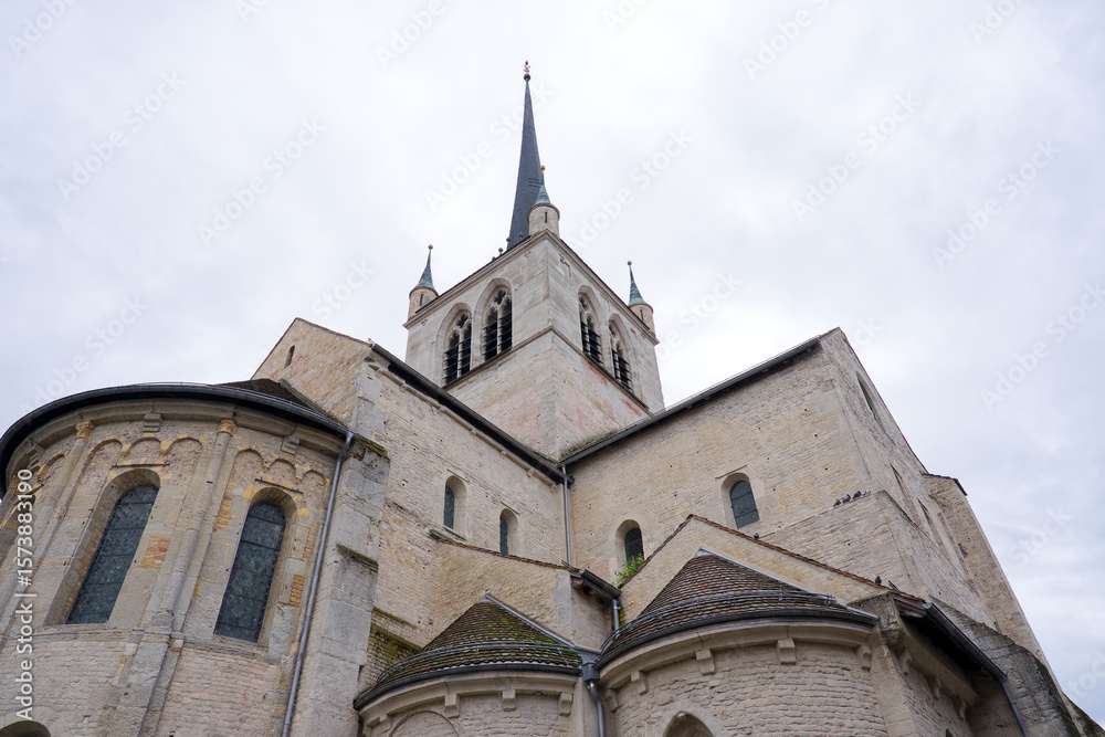 Fototapeta premium Looking up abbey church at Swiss city of Payerne on cloudy spring day. Photo taken June 6th, 2025, Payerne, Switzerland.