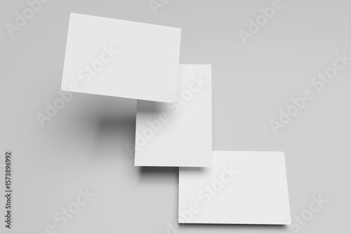 Wallpaper Mural Three white A4 paper, magazine, or business card mockups floating diagonally with soft shadows isolated on grey background. Torontodigital.ca