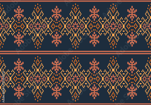 This pixel-style fabric pattern features symmetrical light orange and beige floral motifs on dark blue background. The design repeats horizontally with traditional, handcrafted textile aesthetics.