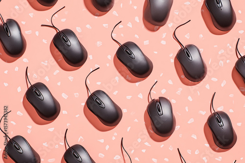 Black Computer mouse hanging on a Pastel Peach Background