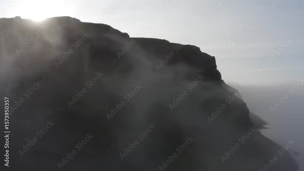 Misty cliff face overlooking a hazy sea