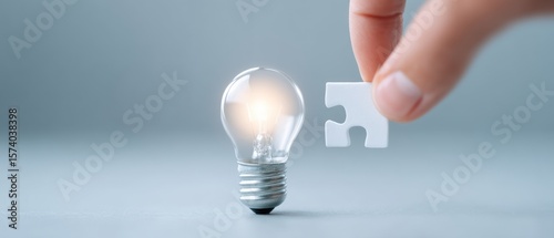 Innovative idea activation a hand placing the final piece into a light bulb studio setting photograph minimalist environment close-up perspective