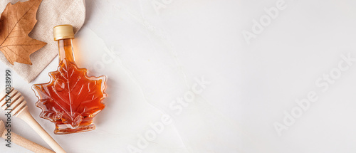 Tableau sur toile Bottle of tasty maple syrup on grey background