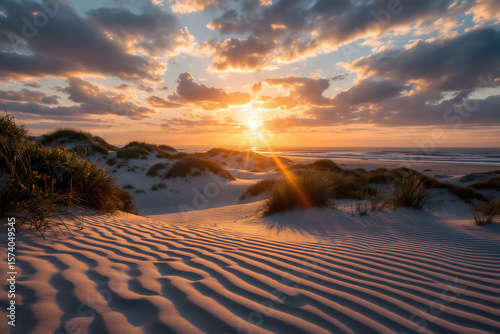 Fototapeta Naklejka Na Ścianę i Meble -  Golden Sunrise Over Rippled Sand Dunes and Ocean Beach Landscape
