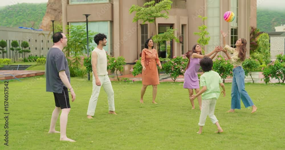 Indian happy family young man woman group play ball game throwing in air have fun joy enjoy outdoor park garden Playful cute teen girl son child kid boy with adult mom lady dad spend day time outside