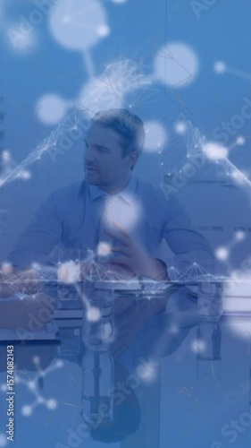 Animation of triangle, floating nucleotides over multiracial coworkers discussing in meeting