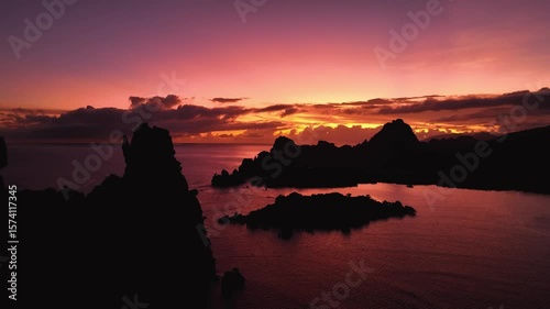 Aerial view of serene coastline with dramatic rock formations at sunset, New Caledonia.