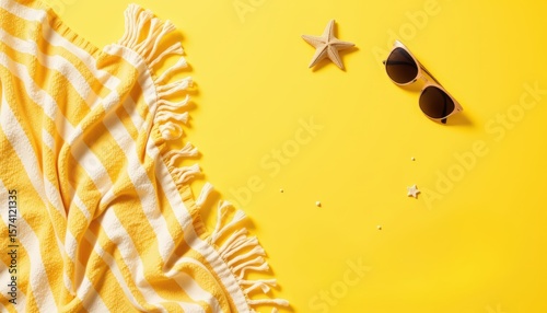 top view of a flat lay composition with yellow beach towel, sunscreen, starfish