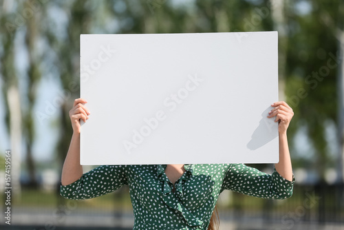 Young woman holding blank p...