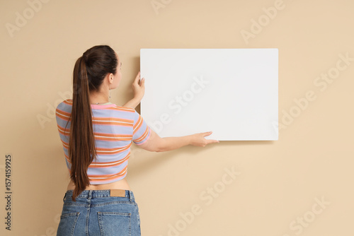 Young woman holding blank p...